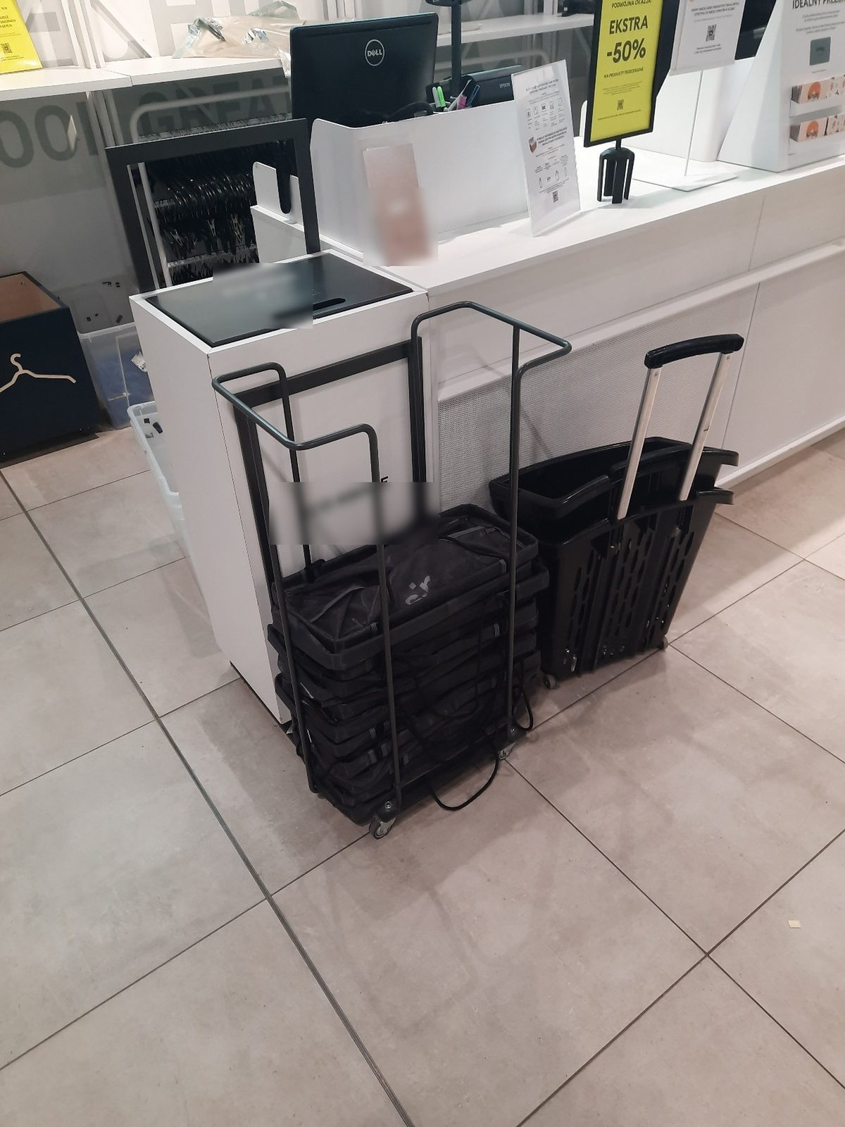 Wheeled baskets and a basket trolley next to a cash desk