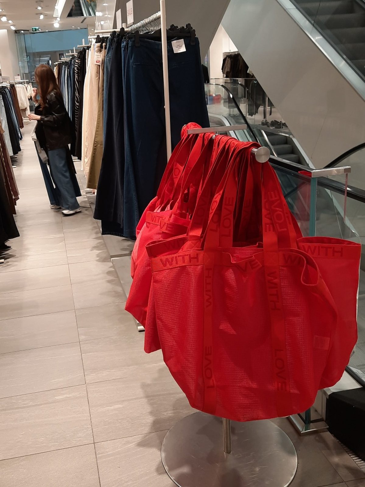 Red fabric shopping bags hanging on a stand