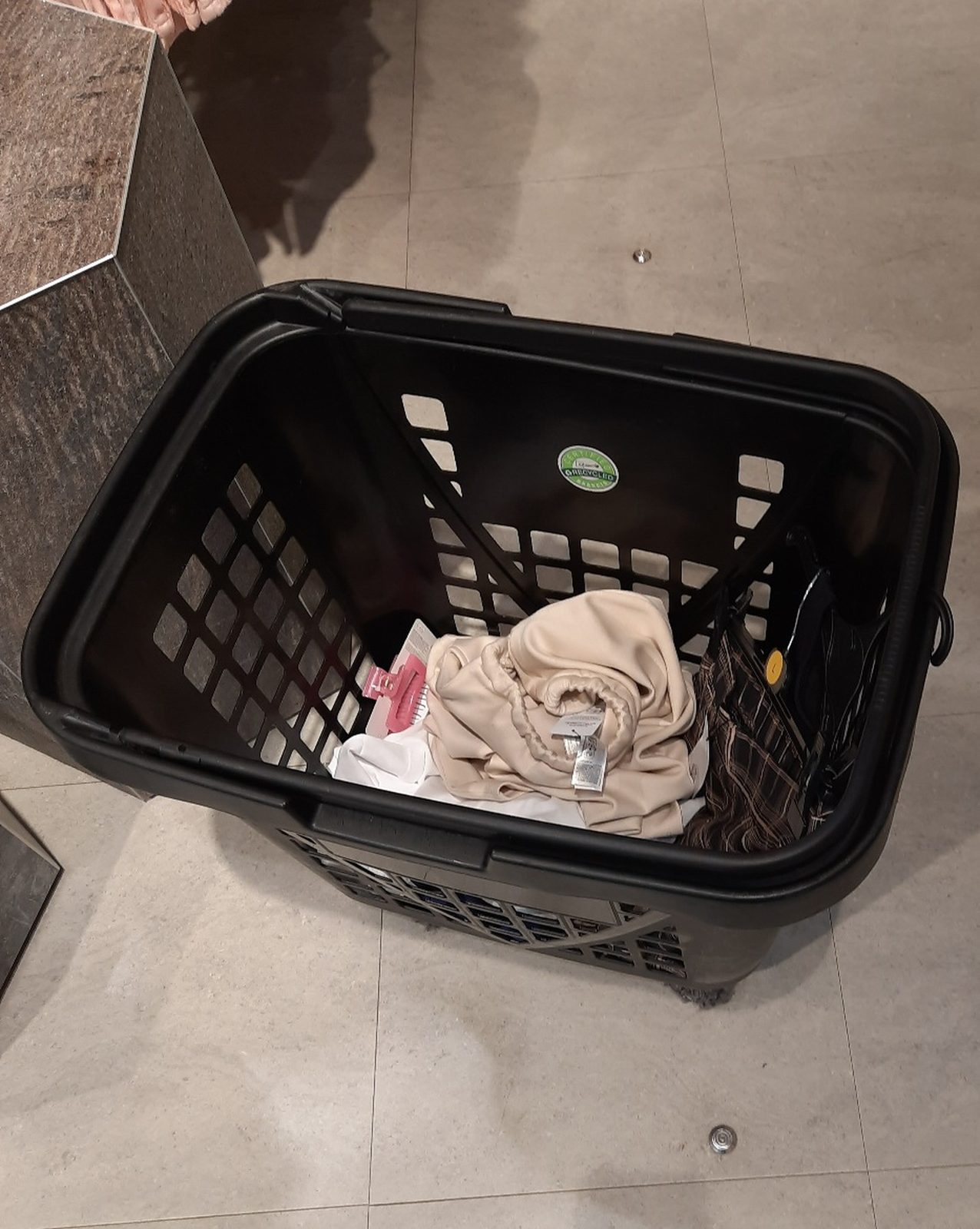 Crumpled garments at the bottom of a plastic shopping basket